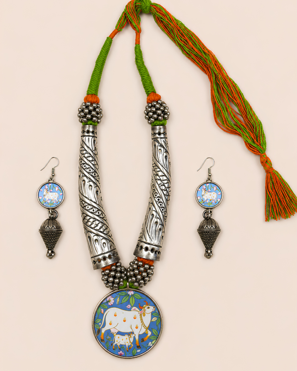Kashish handcrafted Indian statement neckpiece set with oxidised silver finish, green and orange threadwork, cow and calf pendant, and matching earrings